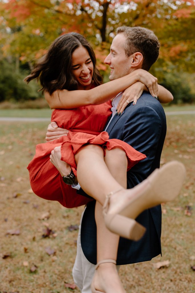 portrait of man and woman in red dress spinning around