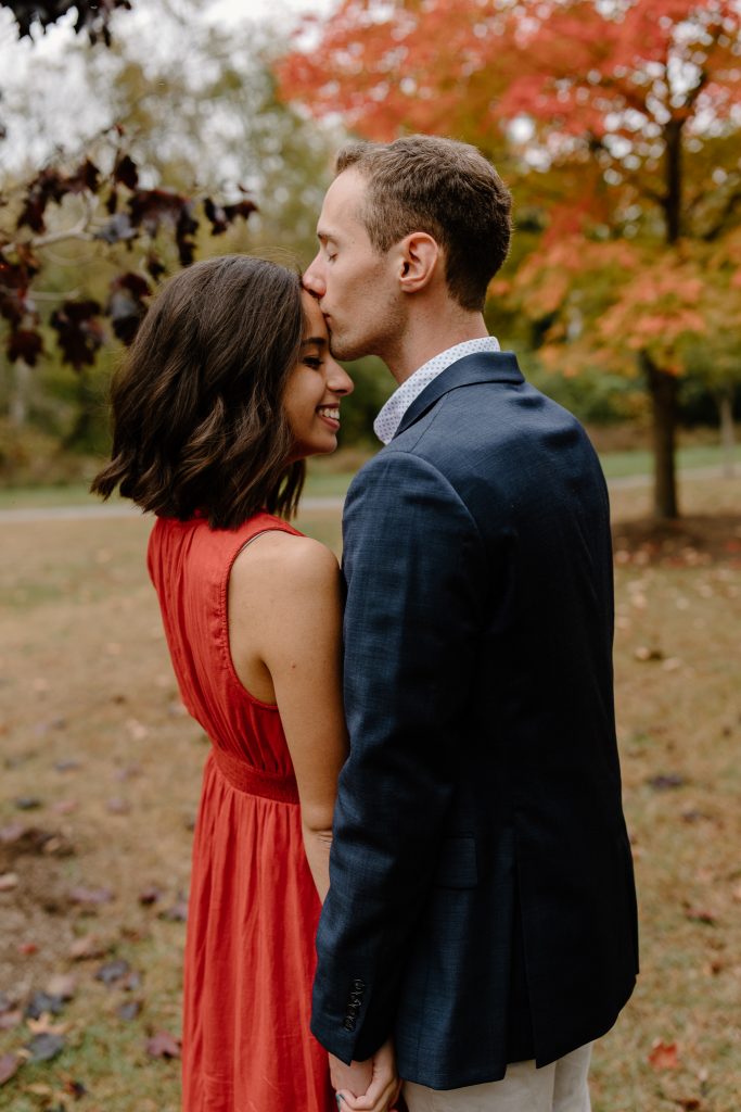 close up portrait of man kissing woman on the head