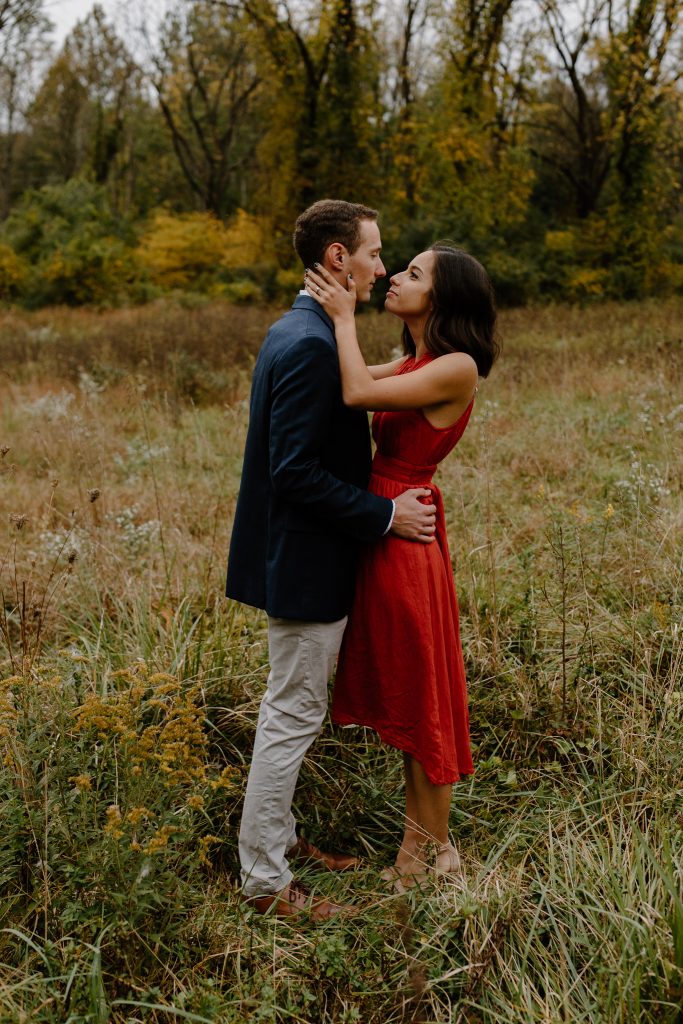 man and woman standing in a field looking at each other