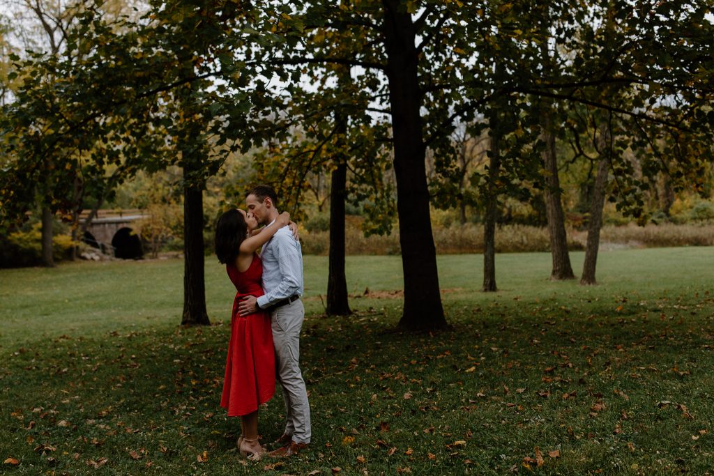 man and woman kissing in a field