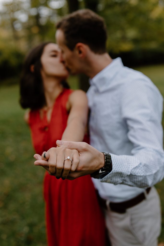 man and woman kissing showing ring