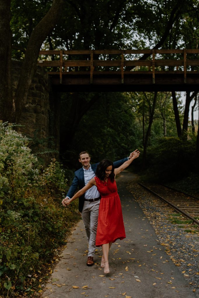 man and woman walking next to railroad tracks