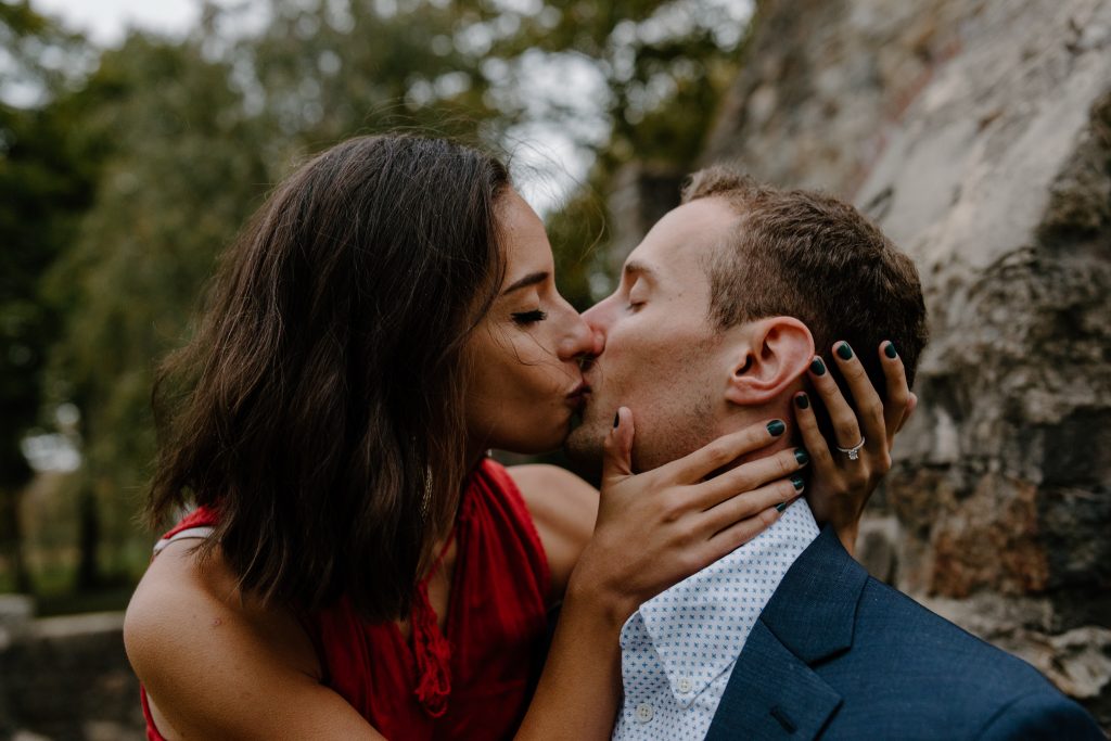 man and woman kissing in the rain