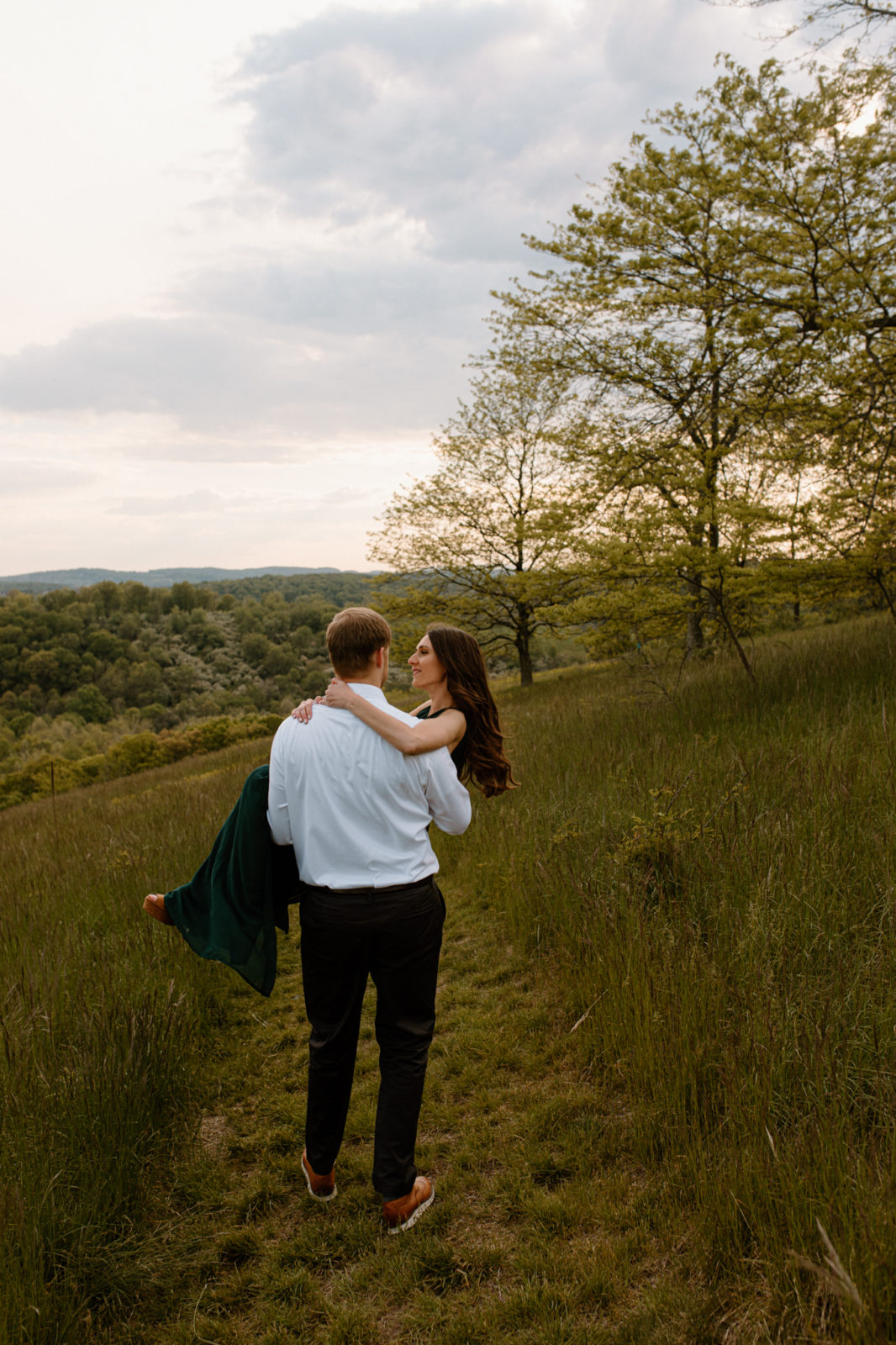 man carrying woman through field