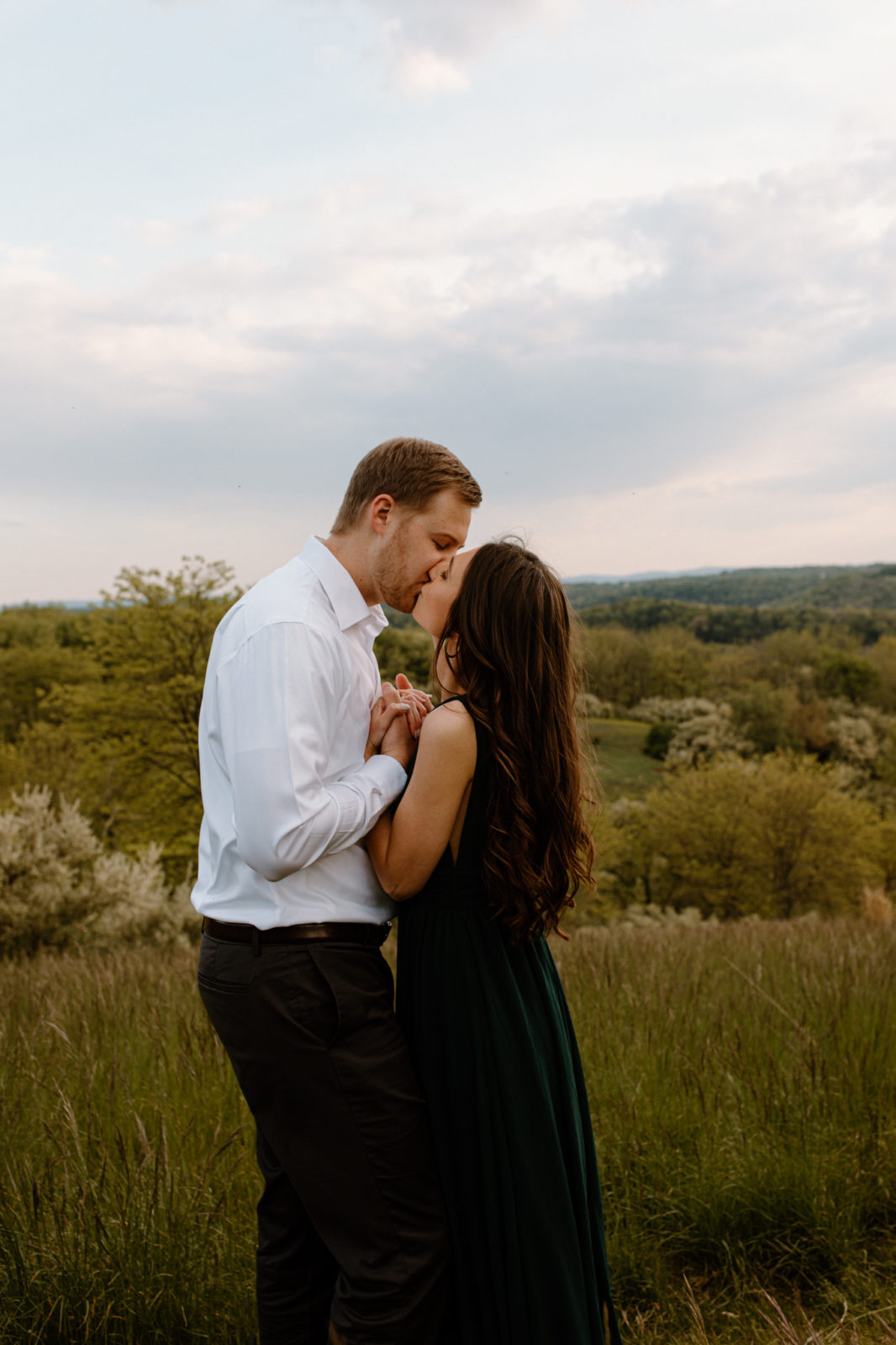 couple kissing with rolling hills in the background